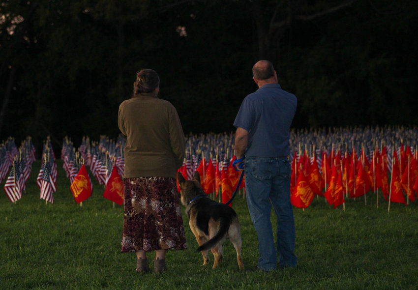 Bill, Rachel, and their dog, Otto, observe the flags in Memorial Field at the Marshfield Remembers Event. Each flag represents a life lost on 09/11/01