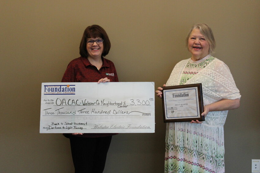 Webster Electric Office Manager Denise Holdman gave a Round Up Grant check to Debby Reece, Supervisor at OACAC Webster County Neighborhood Center.   OACAC received $3,300 from the Round-Up grant, which will be used for Back to School vouchers and Darkness into Light training.   Mail Photo by J.T. Jones