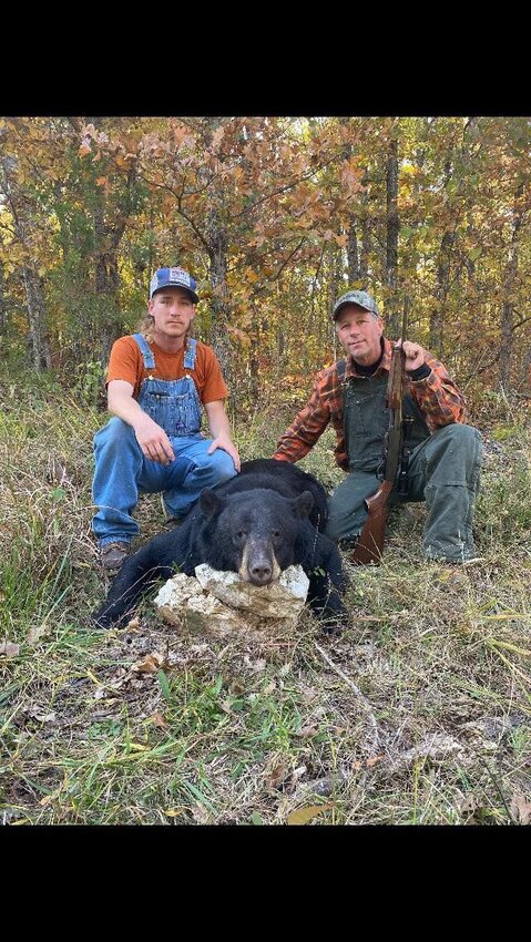 Gage (left) and Doug (right) Fannen pose with a black bear harvested on the Fannen family farm just inside Douglas County. Both of the father/son duo harvested a bear during this year's season after being selected in the lottery for permits.