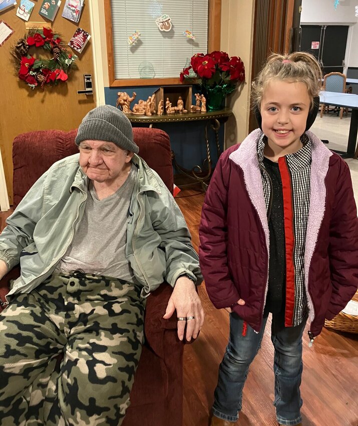 Howard Nease (Left), a resident from Webco Manor, was one of the 215 residents who received his wish for a recliner through the Adopt-An-Angel program. Bailey Terry (Right), a fourth grader from Shook Elementry, was one of the several students who spent their Saturday singing carols and handing out cards and gifts to the senior residents of Marshfield Care, Marshfield Place, Webco Manor, and Strafford Care.   Contributed Photo