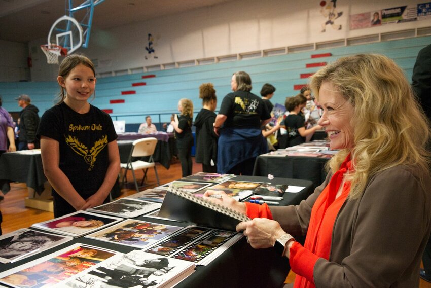Sheree J. Wilson signs an autograph for a young fan at the 