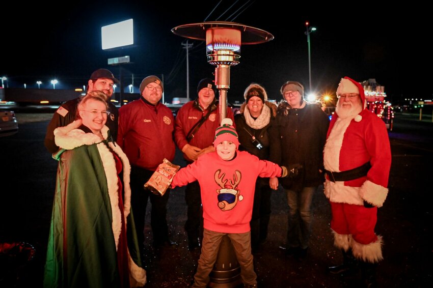 MFPD members join Santa under a heat source during one of the many stops made during the sleigh ride tours through Marshfield the last two Fridays.   Contributed Photo