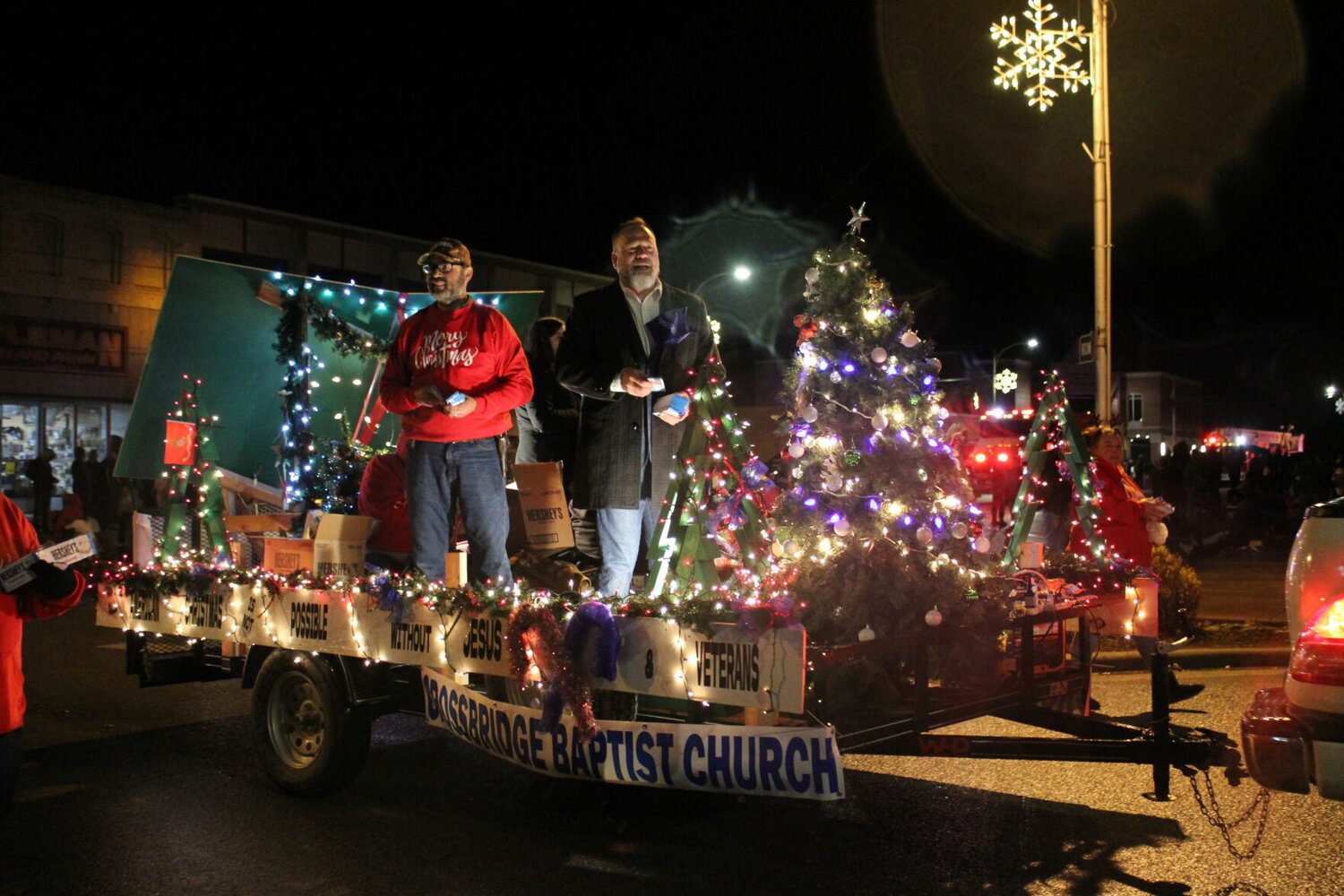 Helping spread the holiday cheer during the Marshfield parade is Judge Justin Evans atop the lighted Crossbridge Baptist Church float.