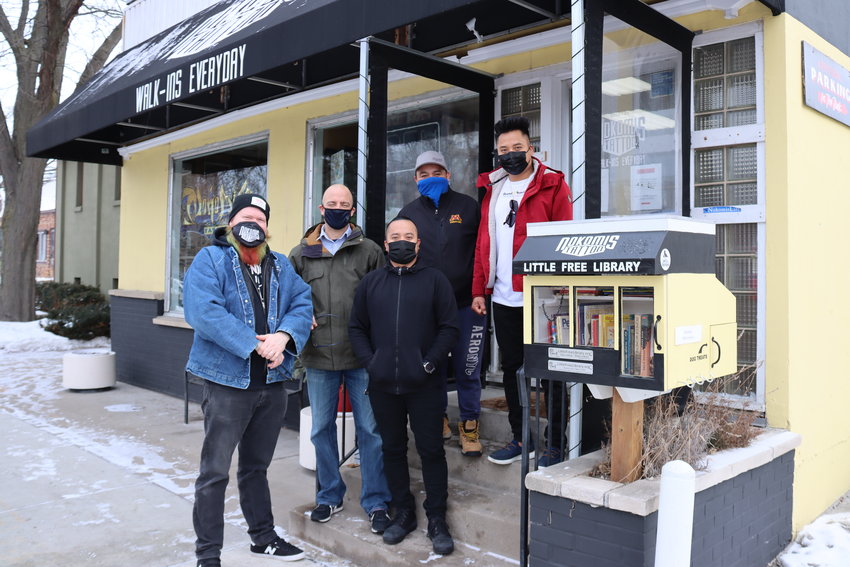 Nokomis Tattoo owner Mike Welch (left) is joined by Ward 11 Council member Jeremy Schroeder, Nokomis Surplus owner Raul Morales, and Grande Sunrise Restaurant owners Javier (front) and Roberto Grande to launch the bilingual Little Free Library on Jan. 20, 2021. (Photo by Tesha M. Christensen)