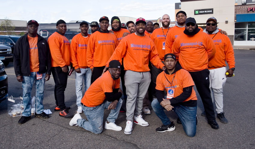 The T.O.U.C.H Outreach community patrol in the Aldi parking lot before heading out for the night. Team leader Muhammad Abdul-Ahad is pictured standing center. (Photo by Margie O&rsquo;Loughlin)