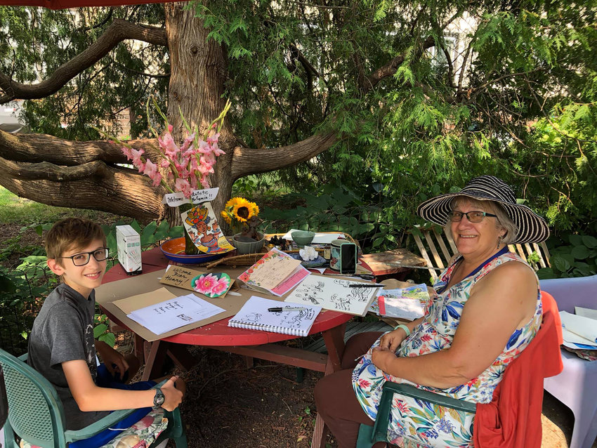 Artist Anita White (right) with art student Henry Holdsworth, in White&rsquo;s garden. (Photo courtesy Hillary Oppmann)