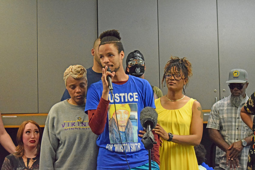 Winston Smith&rsquo;s brother Kidale Smith (center) speaks as Winston&rsquo;s mother, Tijuana Wilson (left) and sister, Tamara Wilson (right) stand by his side. (Photo by Jill Boogren)