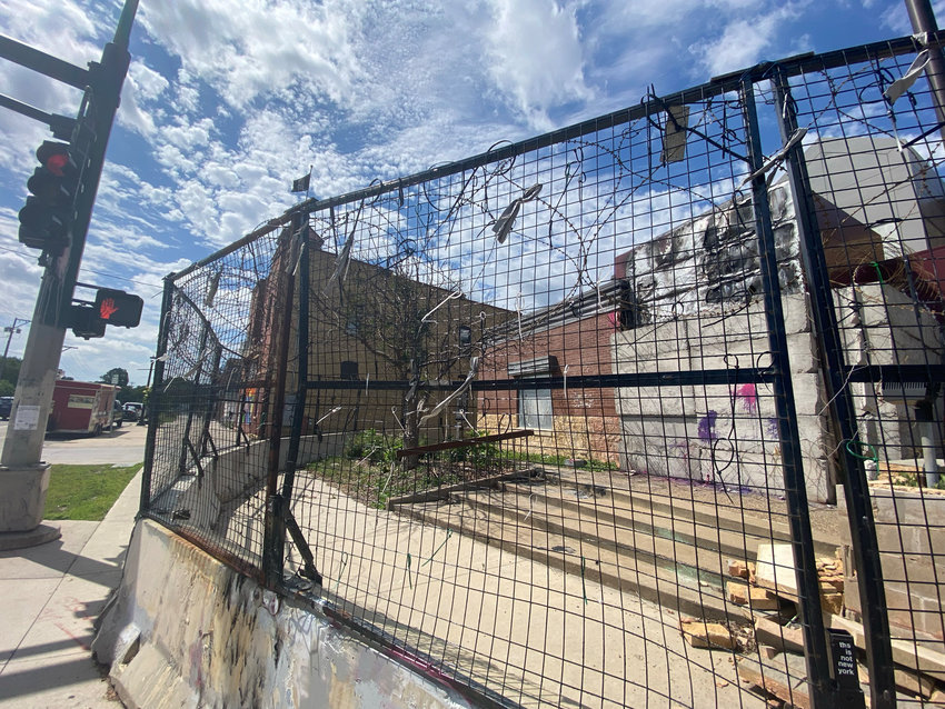 The front of the Third Precinct as residents still see it two years later through a fence, barricades and barb wire. (Photo by Tesha M. Christensen)