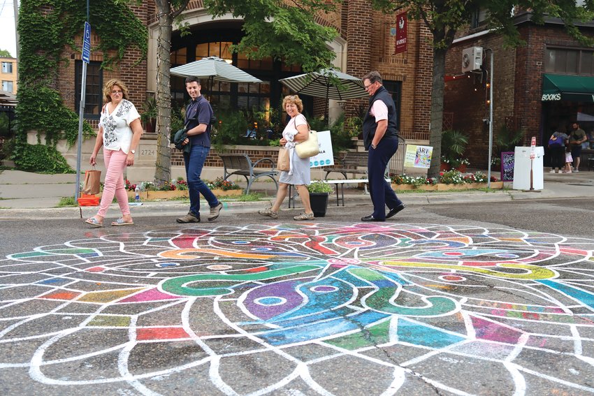 Milwaukee area residents Mari Akre, PJ Akre, Marie Akre and Paul Akre look at the chalk art mandala, created under the guidance of Sandy Forseth for the Art on the Edge event in Linden Hills on July 23, 2022. The Akres were celebrating Mari&rsquo;s 65th birthday. &ldquo;This is a really quaint place to hang out,&rdquo; said Paul Akre. &ldquo;It&rsquo;s the little things that bring out joy. It isn&rsquo;t that far away. You just have to look for it.&rdquo; (Photo by Tesha M. Christensen)