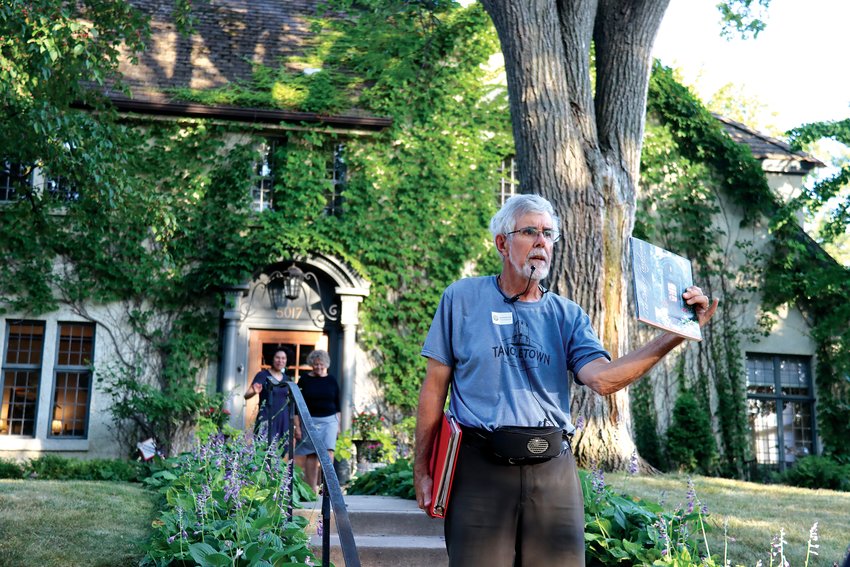 Tom Balcom stands near the residents of the house at 5017 Belmont Ave.  that is on the cover of &ldquo;The Doors of Tangletown&rdquo; by Elizabeth A. Vandam, published in 2002. View more photos from the tour online at www.swconnector.com.  (Photo by Tesha M. Christensen)