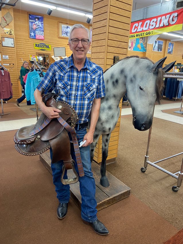 Gary Schatzlein stands in Schatzlein&rsquo;s Saddle Shop at 413 W Lake St., holding a saddle that needs to be repaired. &ldquo;It has been hard to compete with online shopping,&rdquo; Gary Schatzlein said. &ldquo;Brands have made it harder for us to buy from them.&rdquo; The horse behind him is one customers used to sit on and see if their apparel fit right. Now, the horse displays a &ldquo;Do Not Touch&rdquo; sign