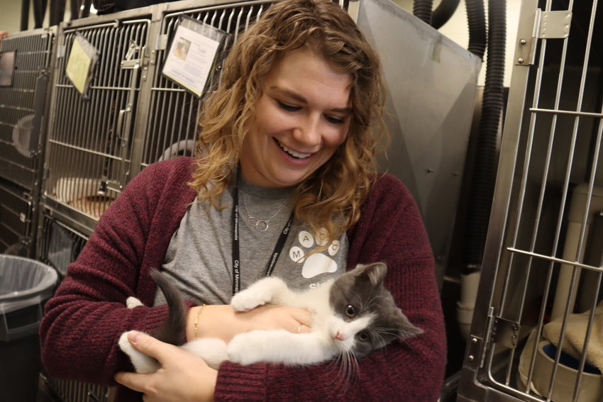 Madison Weissenborn holds three-month-old Llasa prior to a free adoption day event on Dec. 9, 2022 meant to clear out the shelter before Christmas.  Weissenborn is the volunteer and community partnership coordinator at Minneapolis Animal Care and Control.  (Photo by Tesha M. Christensen)