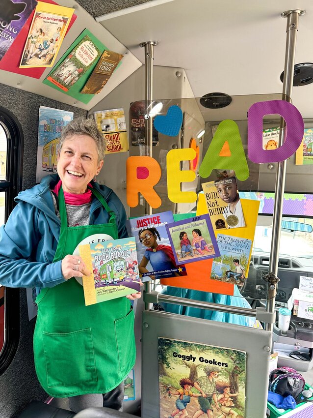 Debbie Beck holds up books in The Free Book Buggie. They've given out over 347,000 books. (Photo submitted)