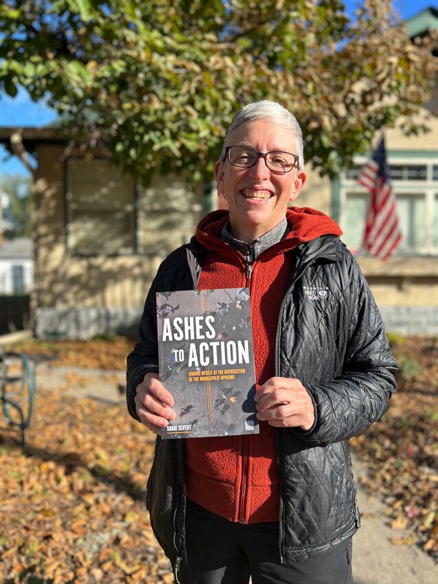 Shari Seifert holds her book, &ldquo;Ashes to Action: Finding Myself at the Intersection of the Minneapolis Uprising,&rdquo; which describes the relationship between Calvary Lutheran Church and the community at George Floyd Square.
