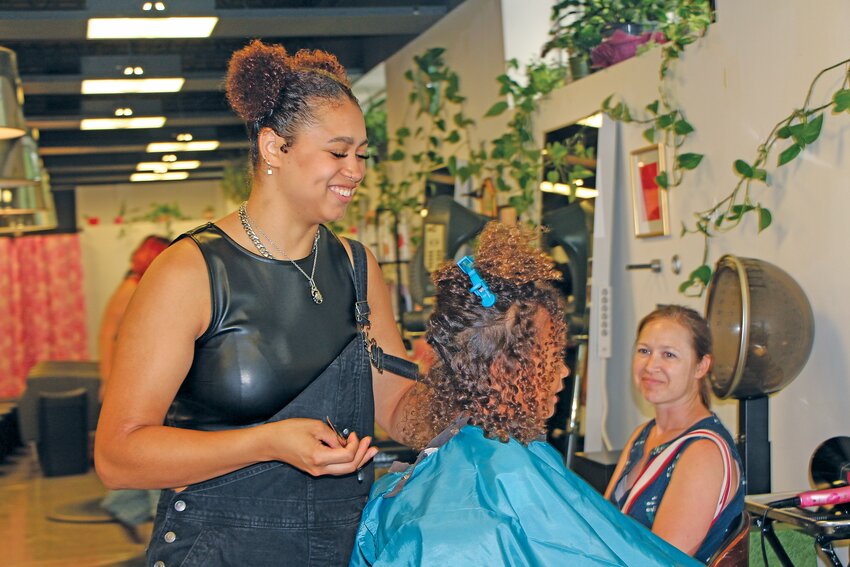 Curl Power stylist Paige Graling trims and styles a young client’s curly hair. Graling was bullied in school growing up because of her natural hair. Now, teaching others about how to care for their natural hair is one of Graling’s passions.