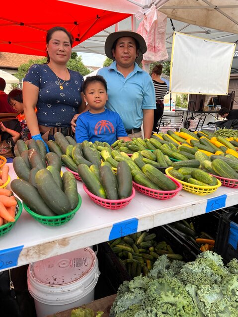 Naton and Panou Vang with one of their twins. The Vangs own Mornin' Sunshine Farm and vend at both the Nokomis and Kingfield Farmers Markets. (Photo submitted)