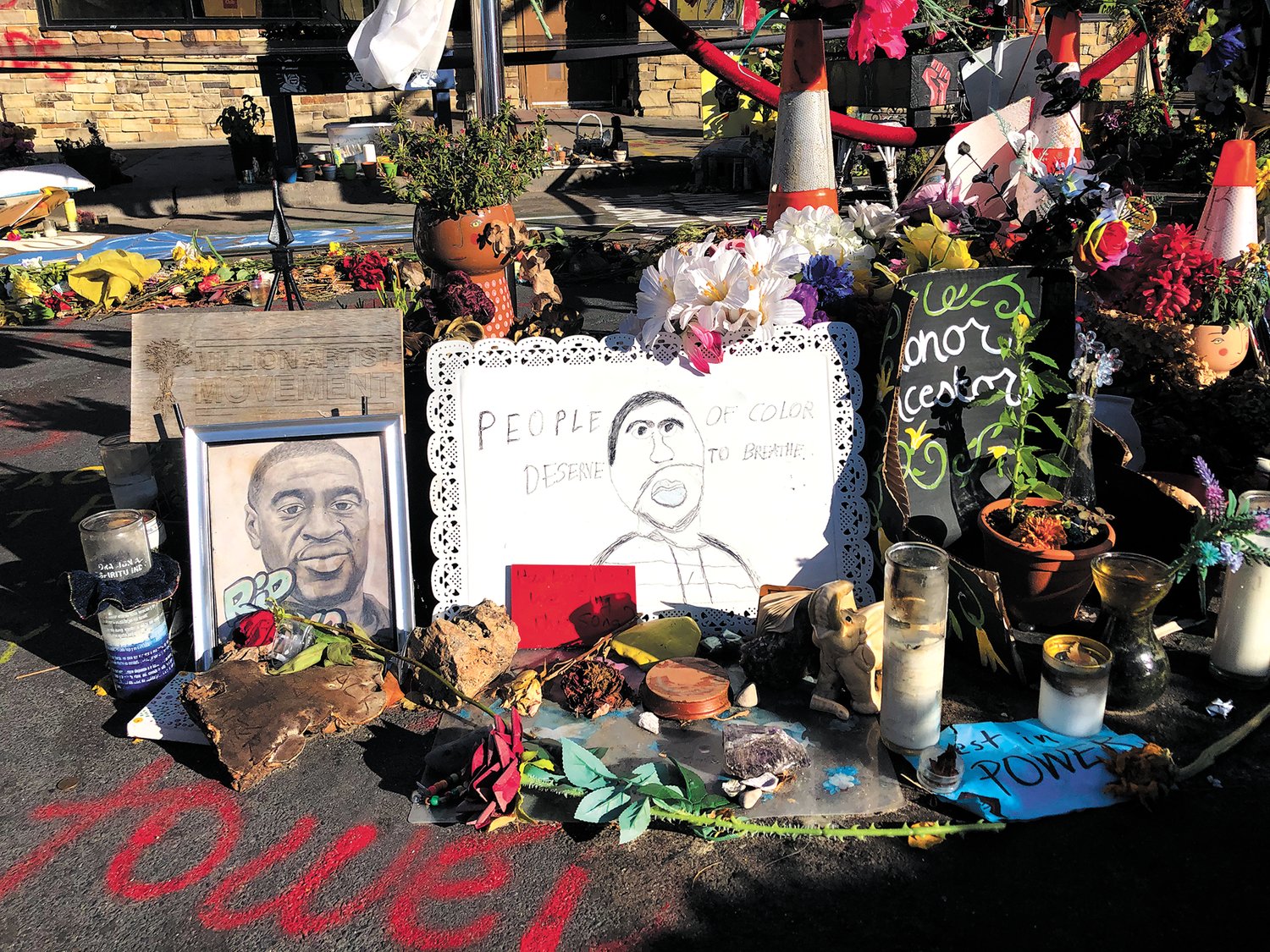 Offerings placed at the George Floyd memorial. Around the drawing in the middle reads “People of Color Deserve to Breathe.” (Photo by Jill Boogren)