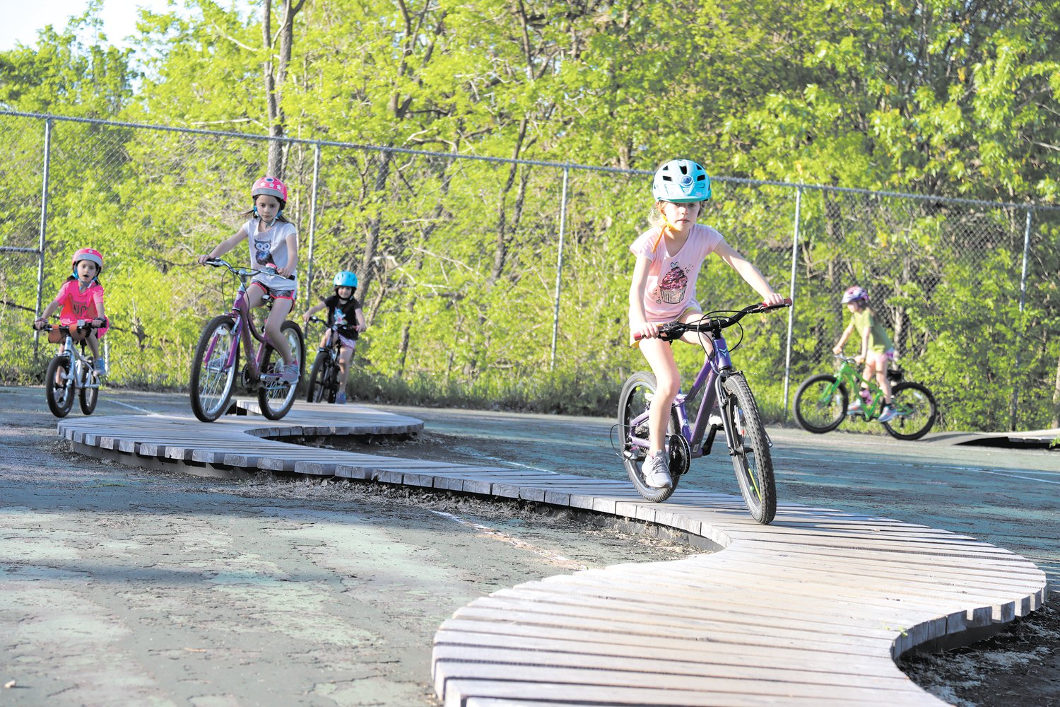 Zaylee Olson (7) leads a group of girls on the snake at the Nokomis Bike Skills Park, the first of its kind in the city. Supporters hope more like it are built.  (Photo by Tesha M. Christensen)