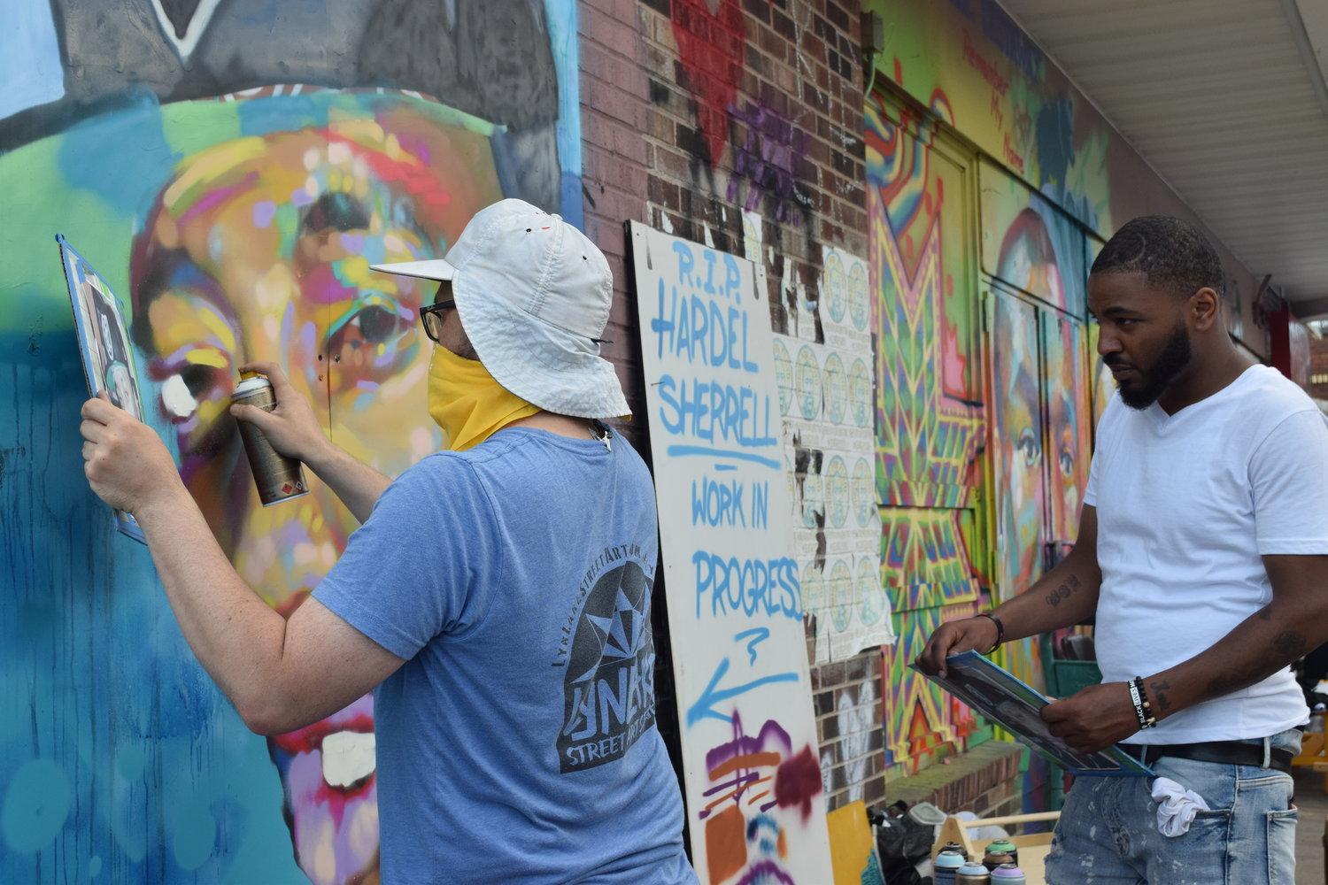 Artists Popeye (wearing white shirt) and Wes Winship put the finishing touches on a mural of Hardel Sherrell, who died while in custody at the Beltrami County Jail. The mural was completed and presented to Sherrell’s mom, Del Shea Perry, at the Rise & Remember event on May 25.
