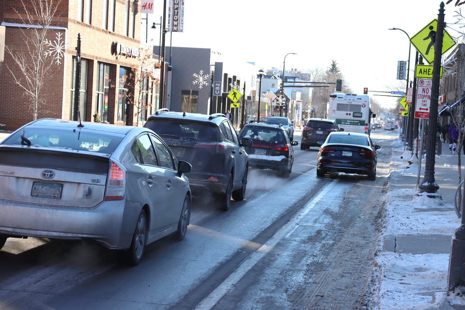 A car stops to load in a bike lane in the area of Hennepin Ave. South between Lake and 31st where all the parking was removed.