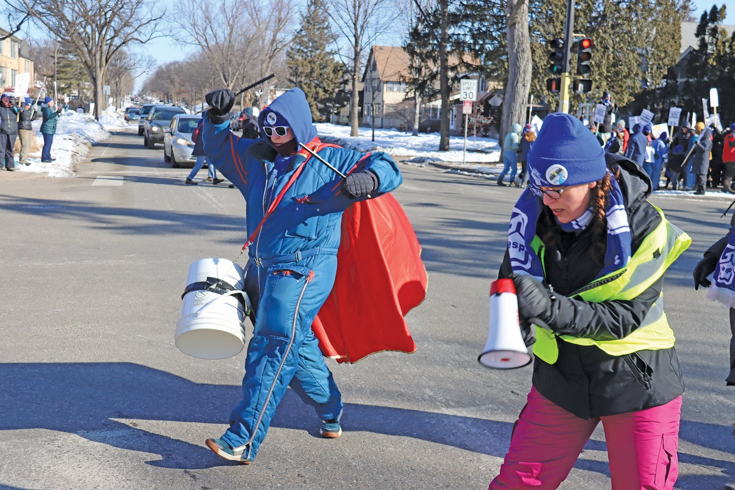 Washburn social studies teacher Cayla Baumann plays the bucket drum at Nicollet and 46th St. on March 11 on a bitterly cold day.  (Photo by Tesha M. Christensen)