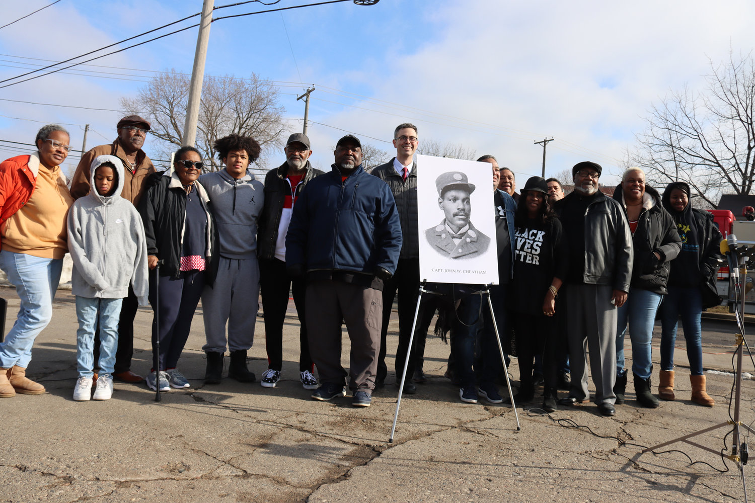 The descendants of John Cheatham, the city’s first Black fire chief,  gather to rename Dight Ave. on March 17, 2022.  At far right is lifetime Longfellow resident Tammy Crockett, who said, “It was awesome” to see the new name be unveiled, honoring her great-great-great-great uncle. Her grandson, 11-year-old Levonte Stephens (in grey sweatshirt), helped during the ceremony when the new name was unveiled from behind the old one. “It was fun to pull the rope off,” he said. (Photo by Tesha M. Christensen)