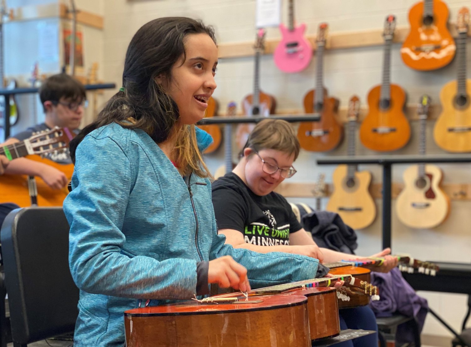 Southwest High School  students Vanessa Hanson (left) and Brynn Sexton learn to  play the guitar in Ruth LeMay’s class. “Students deserve a guitar education,” said LeMay. “It is a lifelong instrument.”