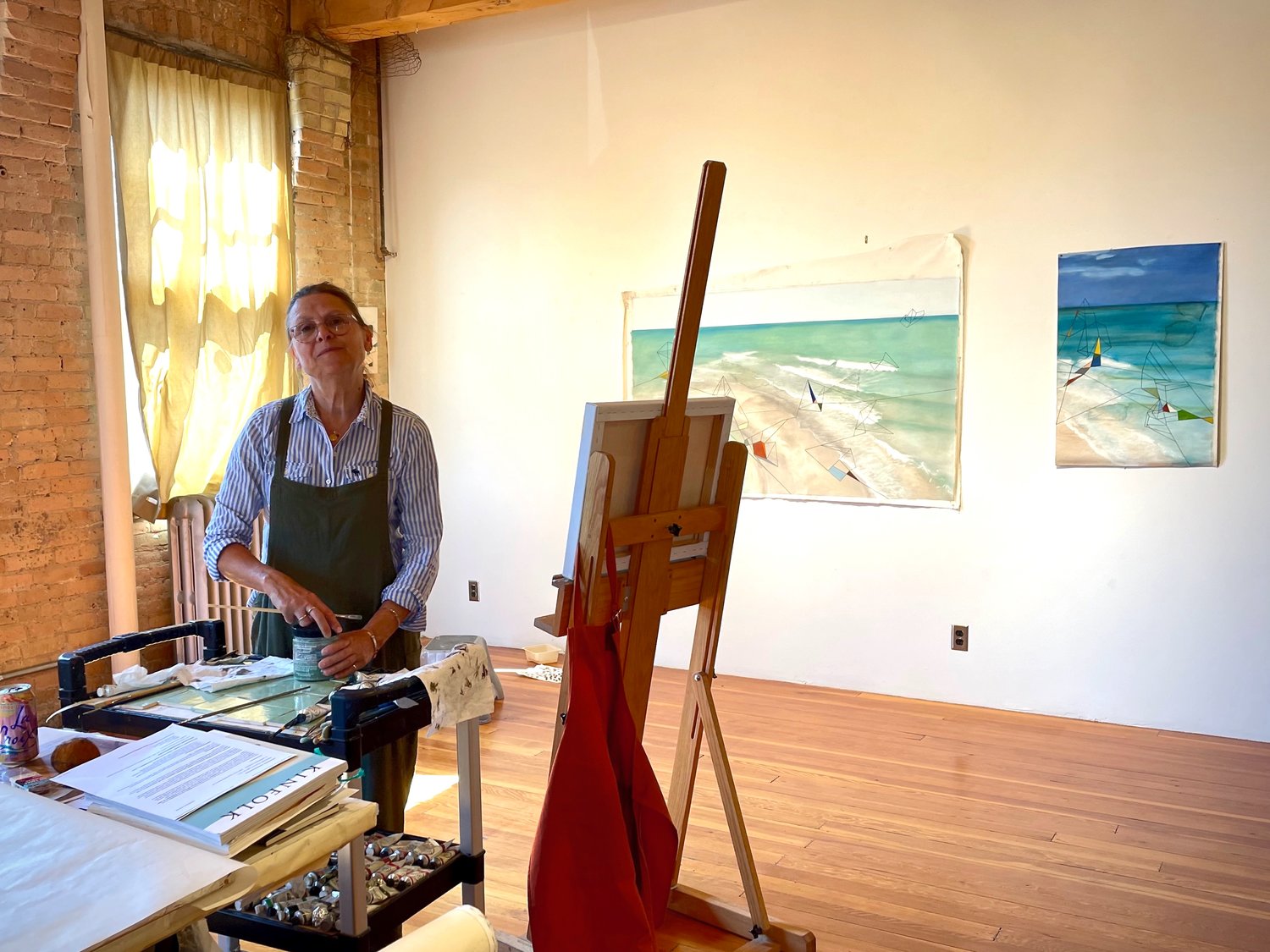 Former NEMAA president, Carmen Gutierrez-Bolger, readies her Casket Art studio for Art-A-Whirl 2022. (Photo by Susan Schaefer)