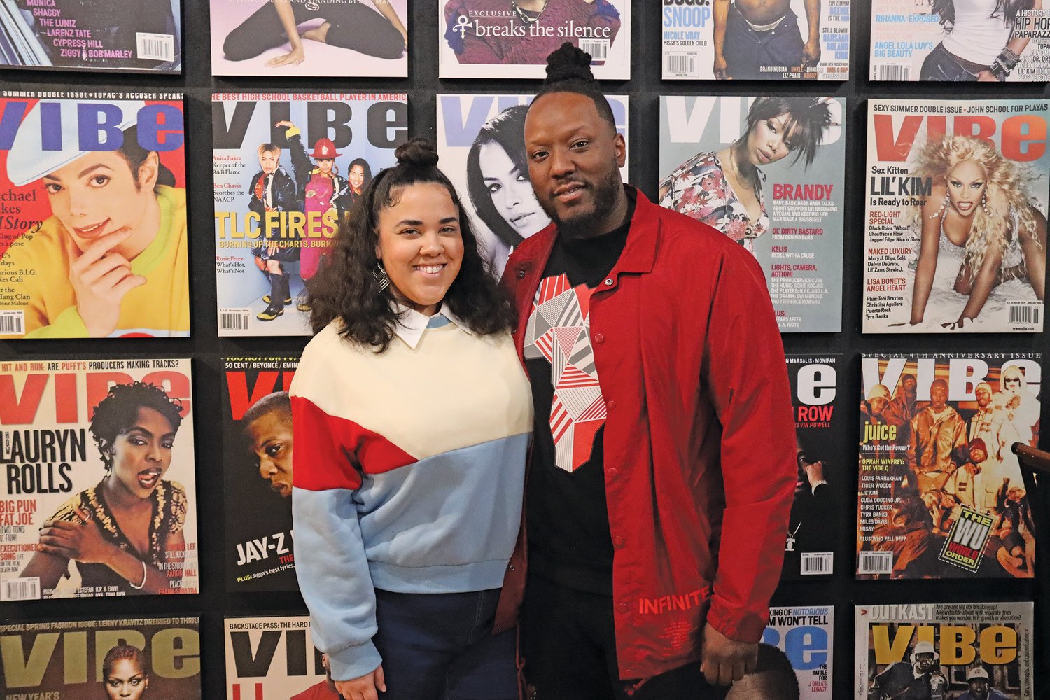 Fancy and Envy (Sarah and Emmanuel Duncan) stand in front of the popular VIBE wall that Fancy created inside The Legacy Building. (Photo by Tesha M. Christensen)