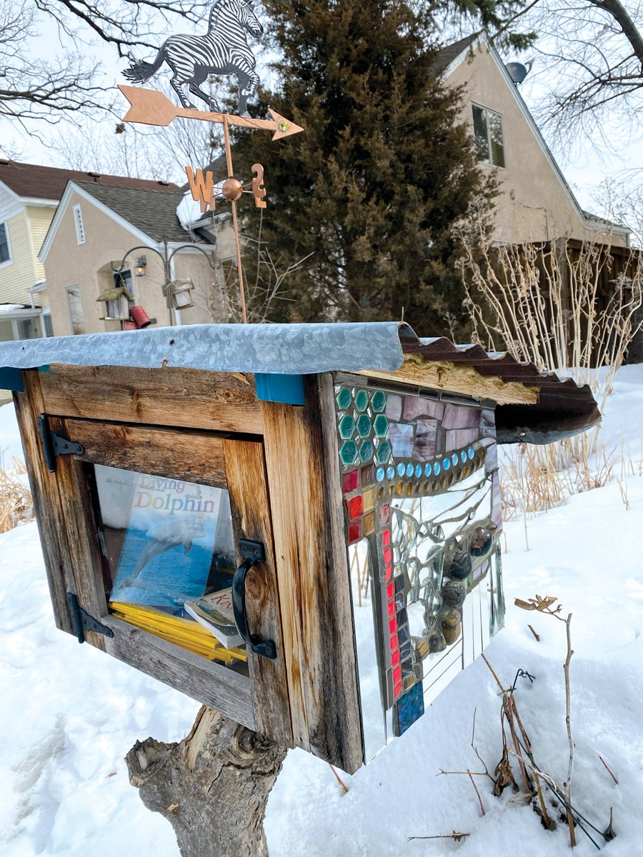 This Little Free Library is adorned with a locally-made Wee Weather Vane.
