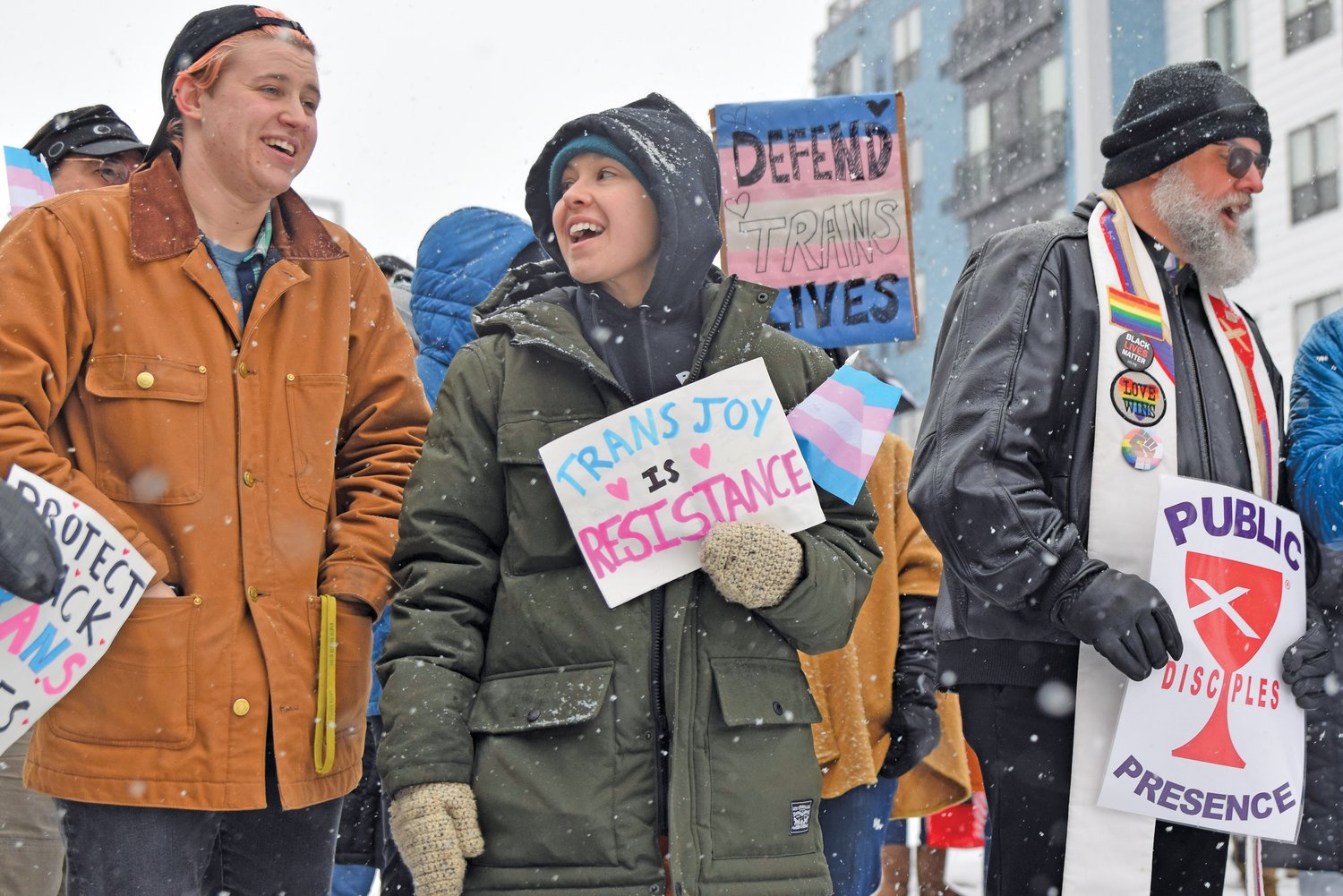 Two demonstrators on March 9 outside the Lake Street/Midtown station share a laugh as one holds up a sign that reads: “Trans joy is resistance.”