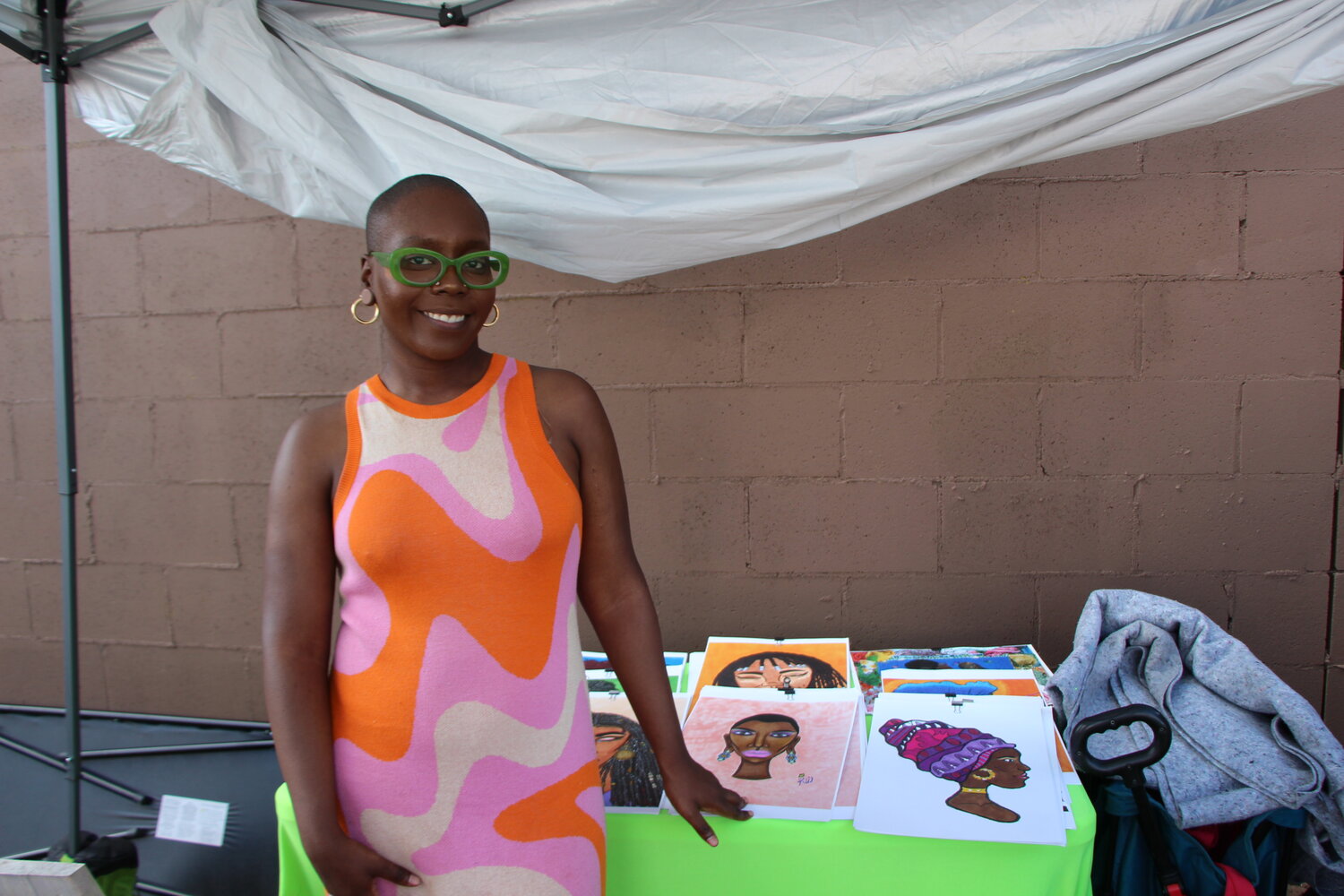 Artist Rajine stands in the vendors area of Juneteenth festival, Soul of the Southside selling her work. Rajine started her business, RajineTheQueenArtistry, during the pandemic making multimedia art about black femininity.