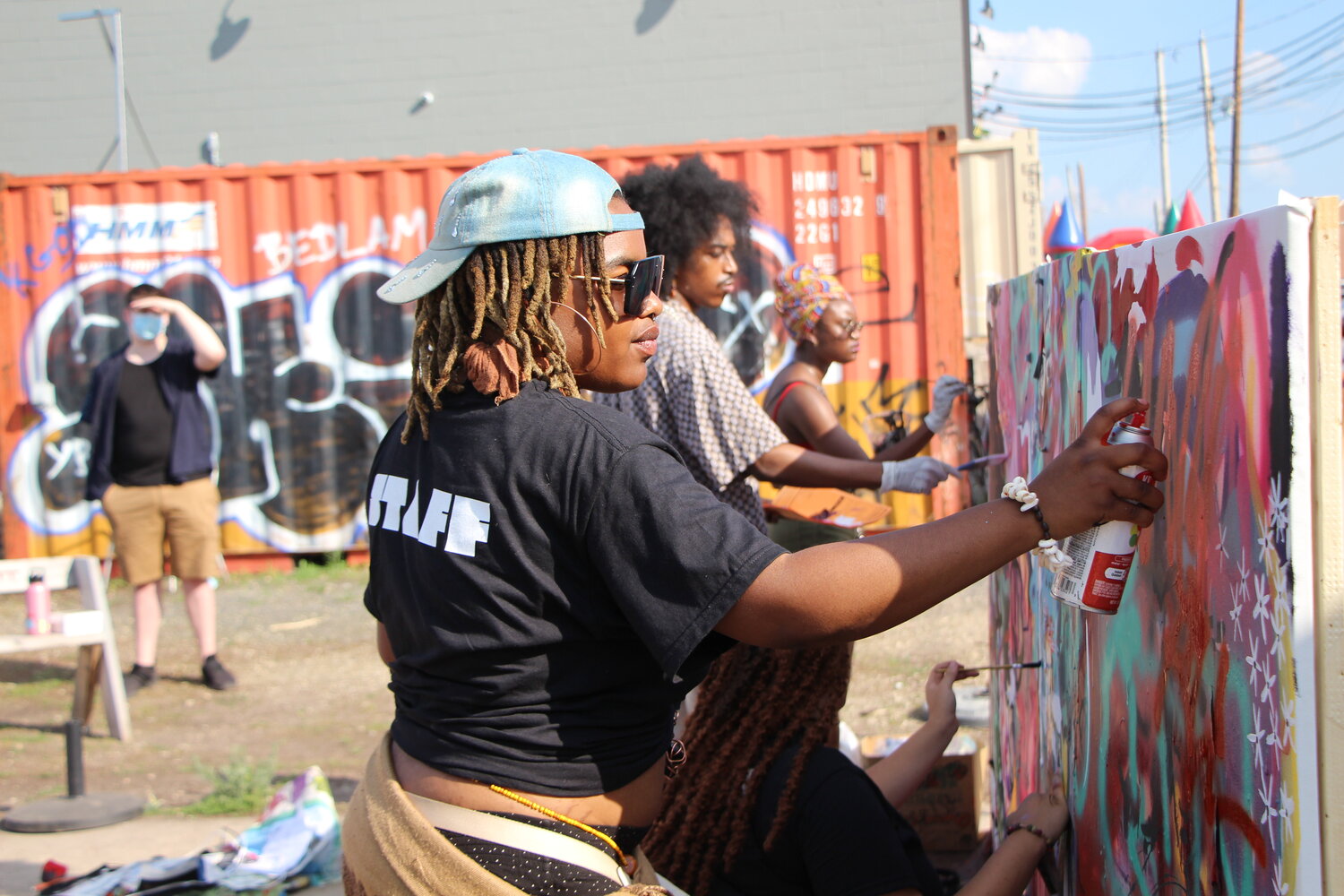 Artist Athena spray paints a graffiti wall with artists at the Soul of the Southside festival on Monday, June 19.