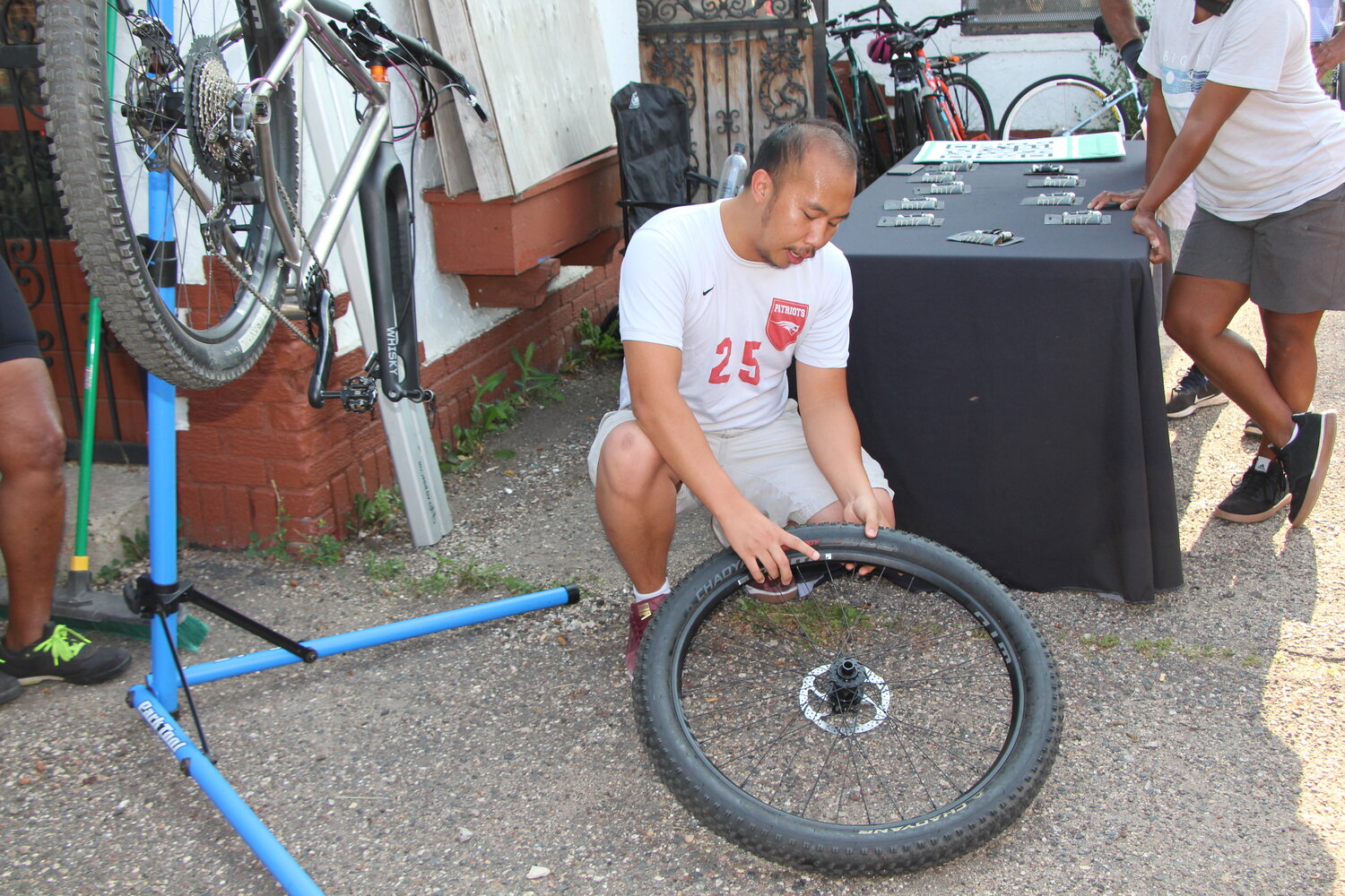 Slow Roll team demonstrates how to change a flat bike tire during the Hotter than July Southside Late Solstice Roll on Thursday, June 29.