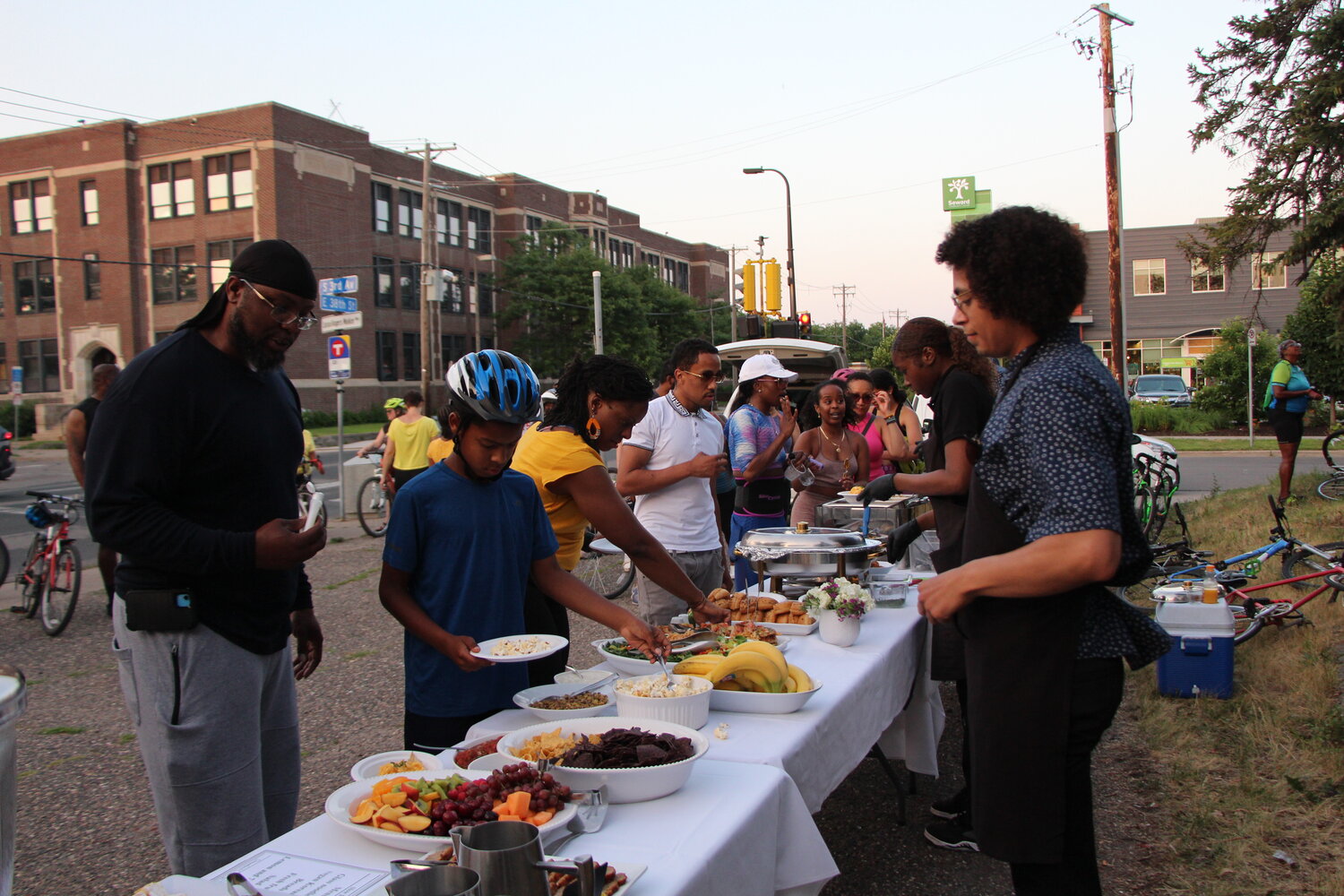 Anthony Taylor, Slow Roll members and team gather and eat together on 3rd Avenue in South Minneapolis at the end of the Hotter than July Southside Late Solstice Roll on Thursday, June 29.