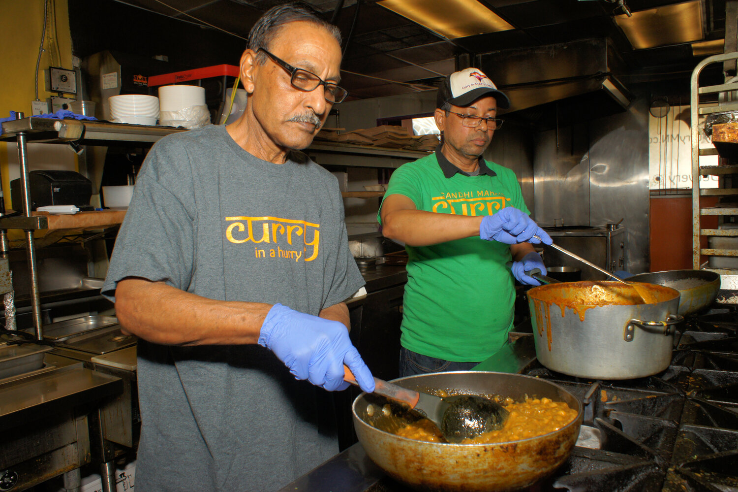 Asmat Ali and Mahmoud Rahman cook chana masala and chicken tikka masala at Curry in a Hurry at 3025 E. Franklin Ave.