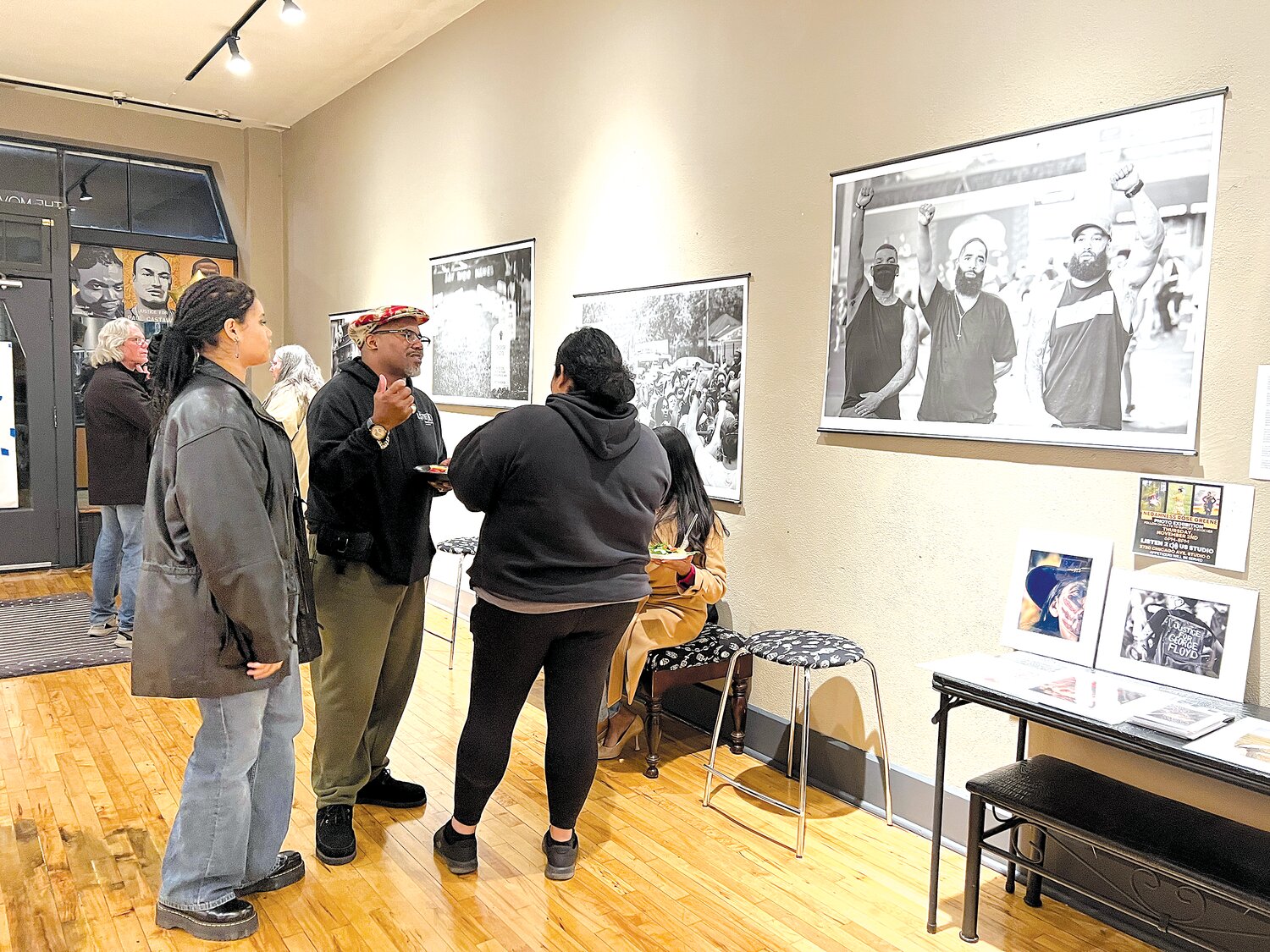 Nedahness Rose Greene (right) speaks with KingDemetrius Pendleton (second from left)at Listen 2 Us Studio at 38th and Chicago. “To have my work that I’ve done here, it’s powerful. Because it happened here, and to be showcasing it right here, it means a lot,” Greene said.