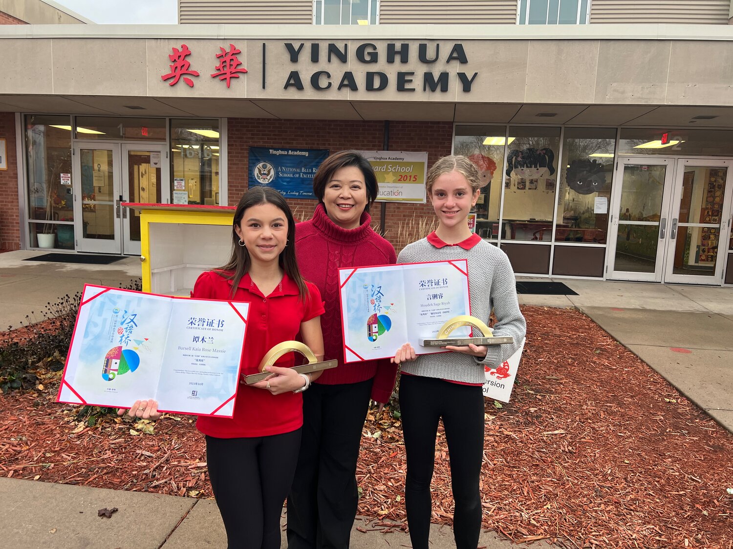 (Left to right) Seventh grader Kaia Bursell, Yinghua Academy Director Dr. Luyi Lien, and sixth grader Sage Houdek hold their certificates and awards from Chinese Bridge.