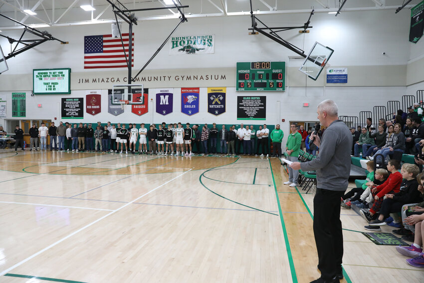 Former Rhinelander and Lakeland head basketball coach spoke about his former player and current boys basketball coach Derek Lemmens as former and current players stand at the end line.