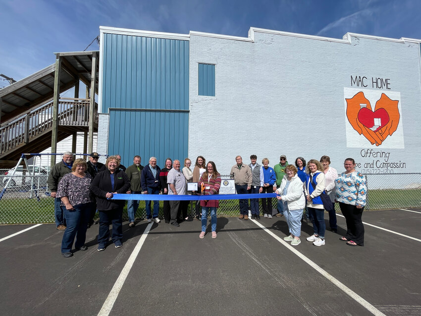 Members of the Optimist Club, the MAC Home Board of Directors and staff, and the Merrill Area Chamber of Commerce gather with City of Merrill officials to celebrate the opening of the small playground to be used by children staying at the MAC Home.