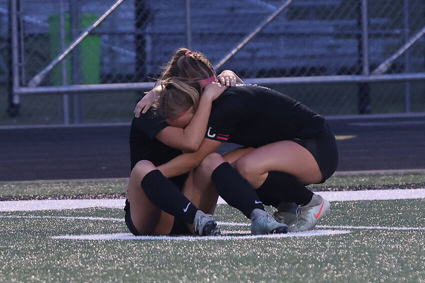 First team all-conference soccer players, and sisters, Sophia and Ella Miljevich console each other with hugs after the playoff loss to Waupaca.