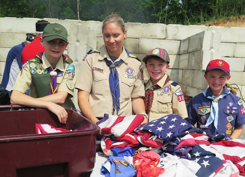 Wautoma American Legion Auxiliary Unit 317 member Katherine Miller took a turn throwing U.S. flags into the fire.