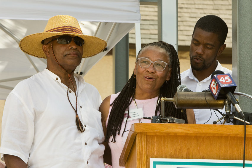 Ramsey County Commissioner Toni Carter (center), husband Melvin Carter Junior (left) and son St. Paul mayor Melvin Carter III (right) commemorated their family&rsquo;s original Rondo home that was uprooted during the construction of I-94 by planting a tree during the Juneteenth Celebration at the Rondo Center of Diverse Expression at 315 Fisk St. (Photo by Margie O&rsquo;Loughlin)