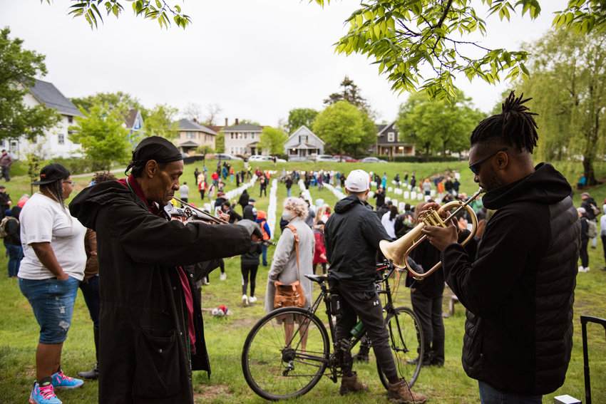 Raycurt Johnson (left) and Butchy Austin (right) play music at Say Their Names Cemetery during the vigil on May 25, 2022. Reverend Jeanette Rupert spoke at the vigil, which was followed by a candlelit walk via the Mourning Passage along Chicago Ave. to the George Floyd Memorial. Once there, members of the Chicago Avenue Fire Arts Center did a bronze pour of a sankofa bird.