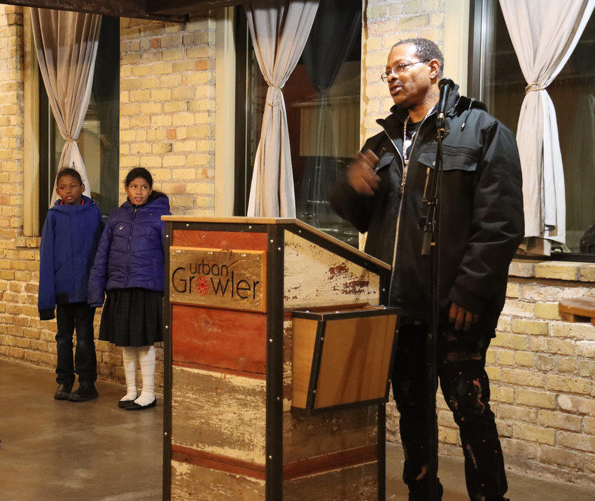 Eugene Johnson and his children (Angelic, age eight, and Angelica, age nine) appreciate the experience they&rsquo;ve had through Shop with Cops. Johnson told Midway Area Chamber of Commerce members about it during a fundraiser on Nov. 30, 2022. (Photo by Tesha M. Christensen)