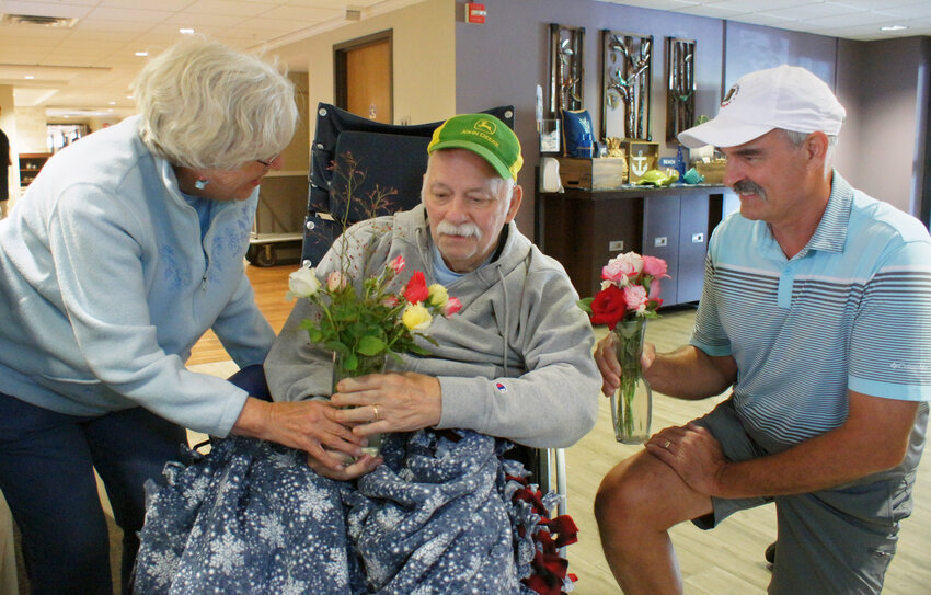 Lyngblomsten residents (left and middle) Lynn and Gary McDonald admire Rob McHattie&rsquo;s flower arrangement. The St. Paul gardener makes sure there are always fresh roses at the Lyngblomsten front desk.