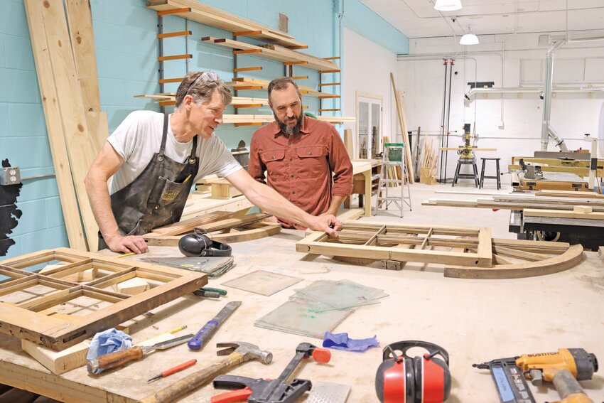 Woodworker Bill Dossett (left) and Joe Hayes look over a set of windows being restored. According to Dossett, the dust collection system in the new building is an upgrade that has made a big difference for staff. Plus there's a room just for planing.