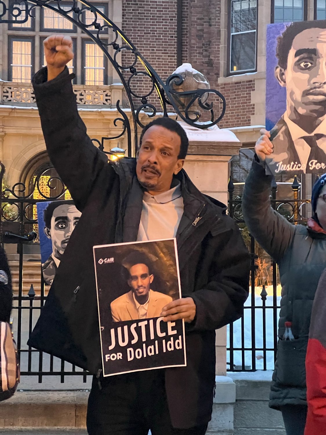 Bayle Gelle, Dolal Idd’s father, raises a fist for justice.
