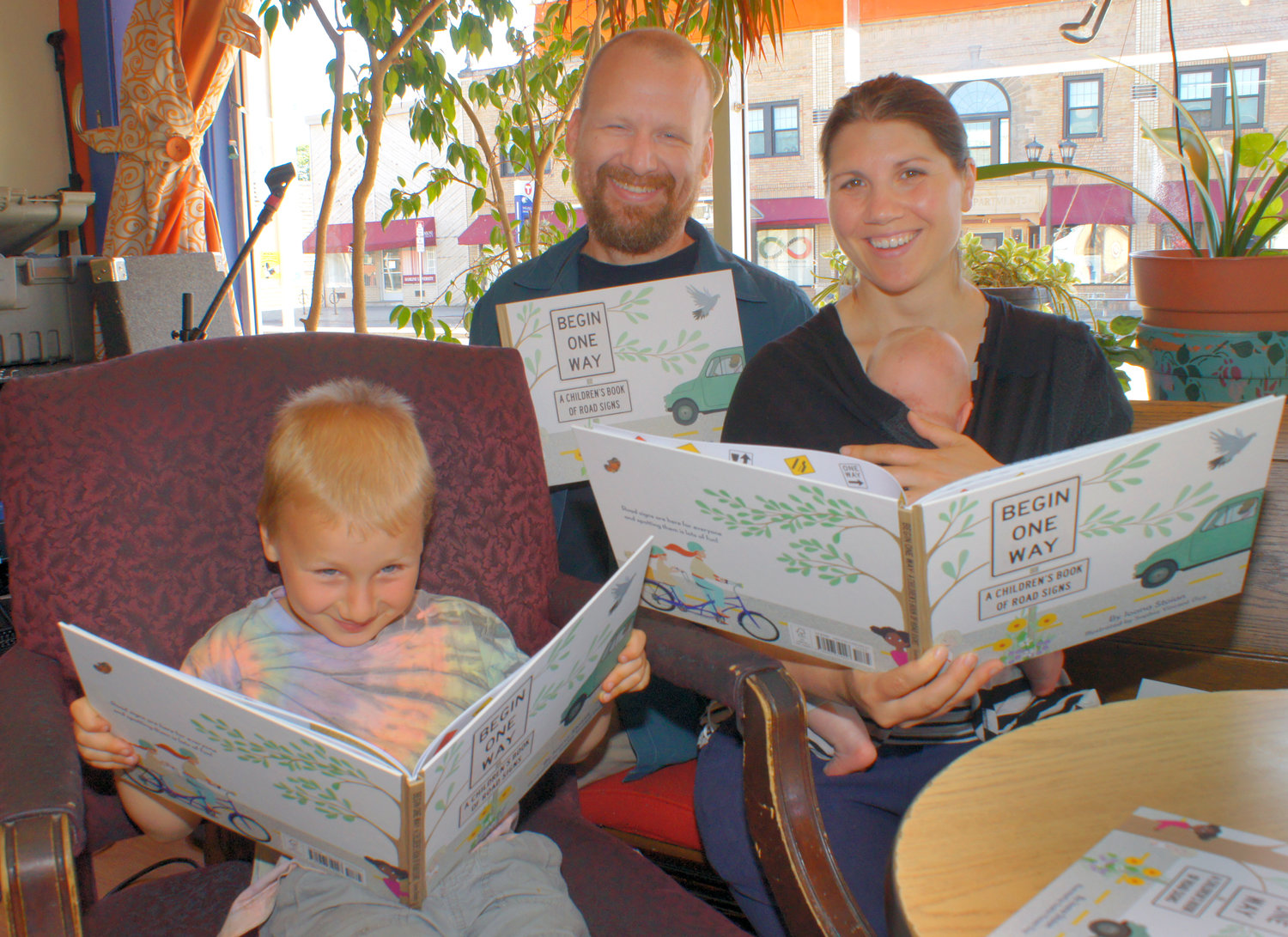 On June 18, Ioana Stoian presented her new book, “Begin One Way: A Children’s Book of Road Signs” at the Gingko Coffee Shop. With her were her husband Eric, 5-year-old son George (aka Biff), and nine-week-old daughter Lydia. (Photo by Terry Faust)