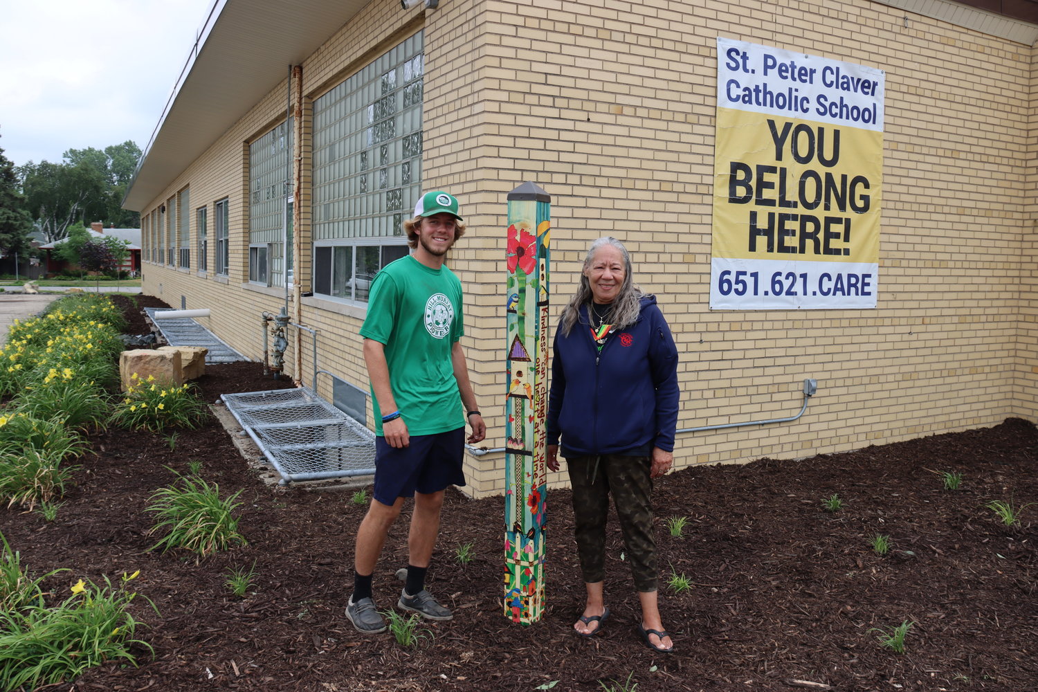 Joshua ‘JP’ Yocum of Pioneer Landscaping and Lynn Wright appreciate how the new landscaping at St. Peter Claver Catholic School turned out. (Photo by Tesha M. Christensen)